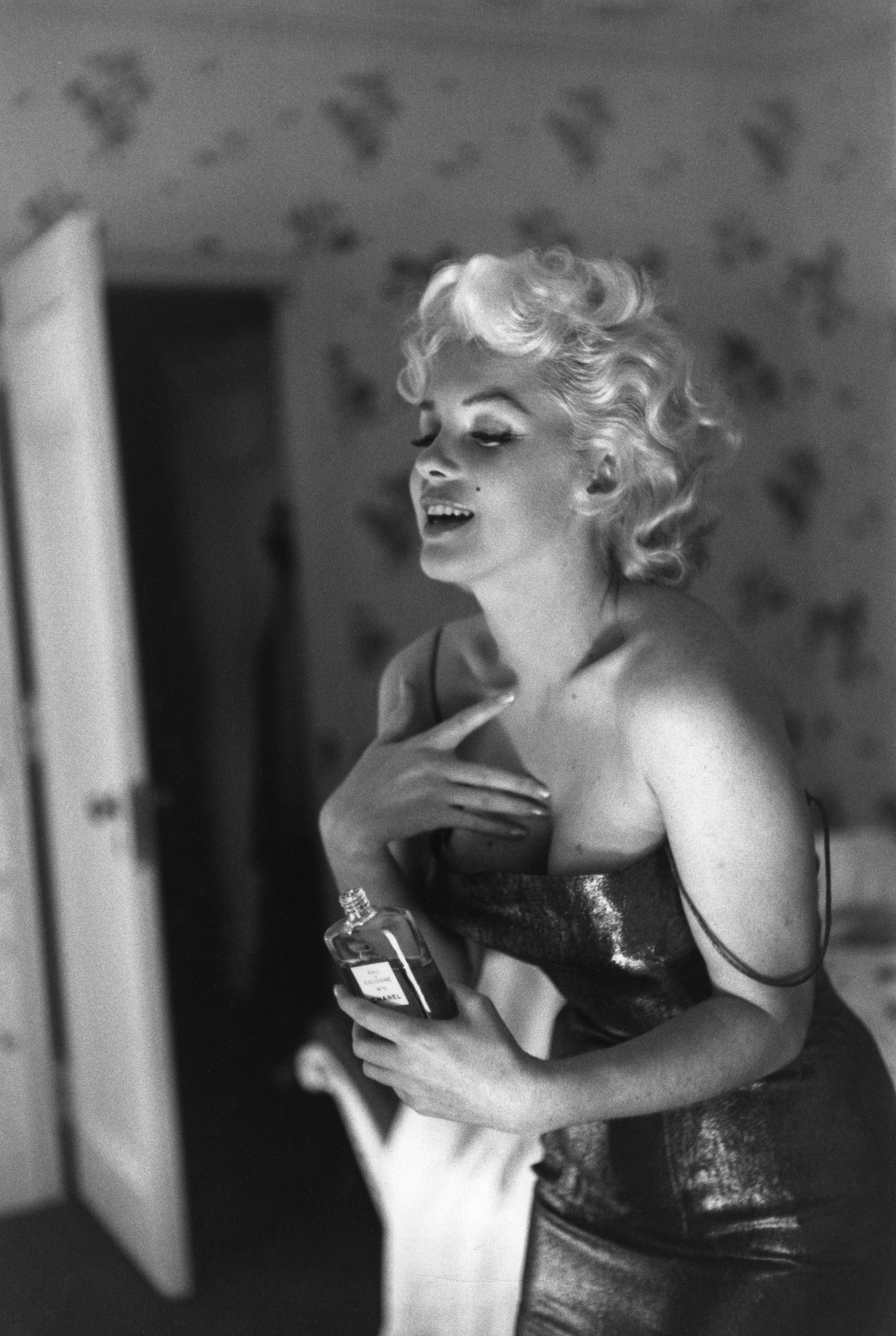 Marilyn Monroe gets ready to go see the play Cat On A Hot Tin Roof playfully applying her make up and Chanel No. 5 Perfume on March 24, 1955 at the Ambassador Hotel in New York City