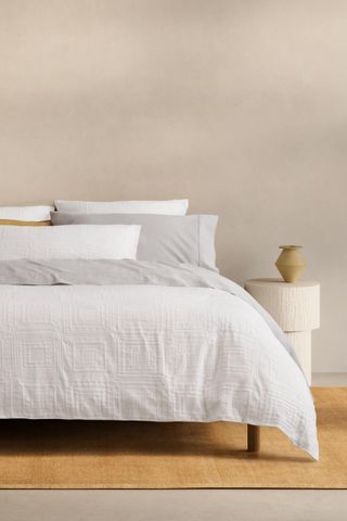 a white bedding set on a bed