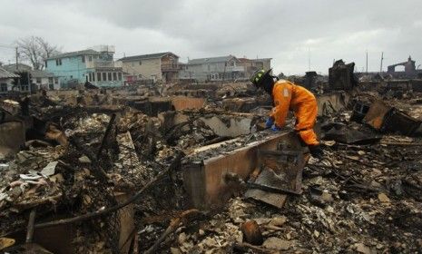 A firefighter looks through debris 