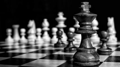 black and white photo of king chess piece on chess board
