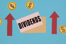 the word "dividends" written on a piece of paper with two red arrows pointing up on either side and dollar signs