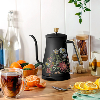 A kitchen countertop with food ingredients and a black gooseneck kettle with a floral pattern