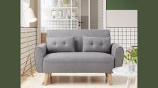 Best small couch: grey two seater Amazon couch in tiny bright room with tiled walls and green paint