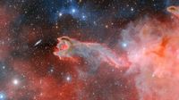 An image of the God's Hand cometary globule. The image features pink and blue clouds against a starry background. One of the clouds is in the shape of a claw or hand.