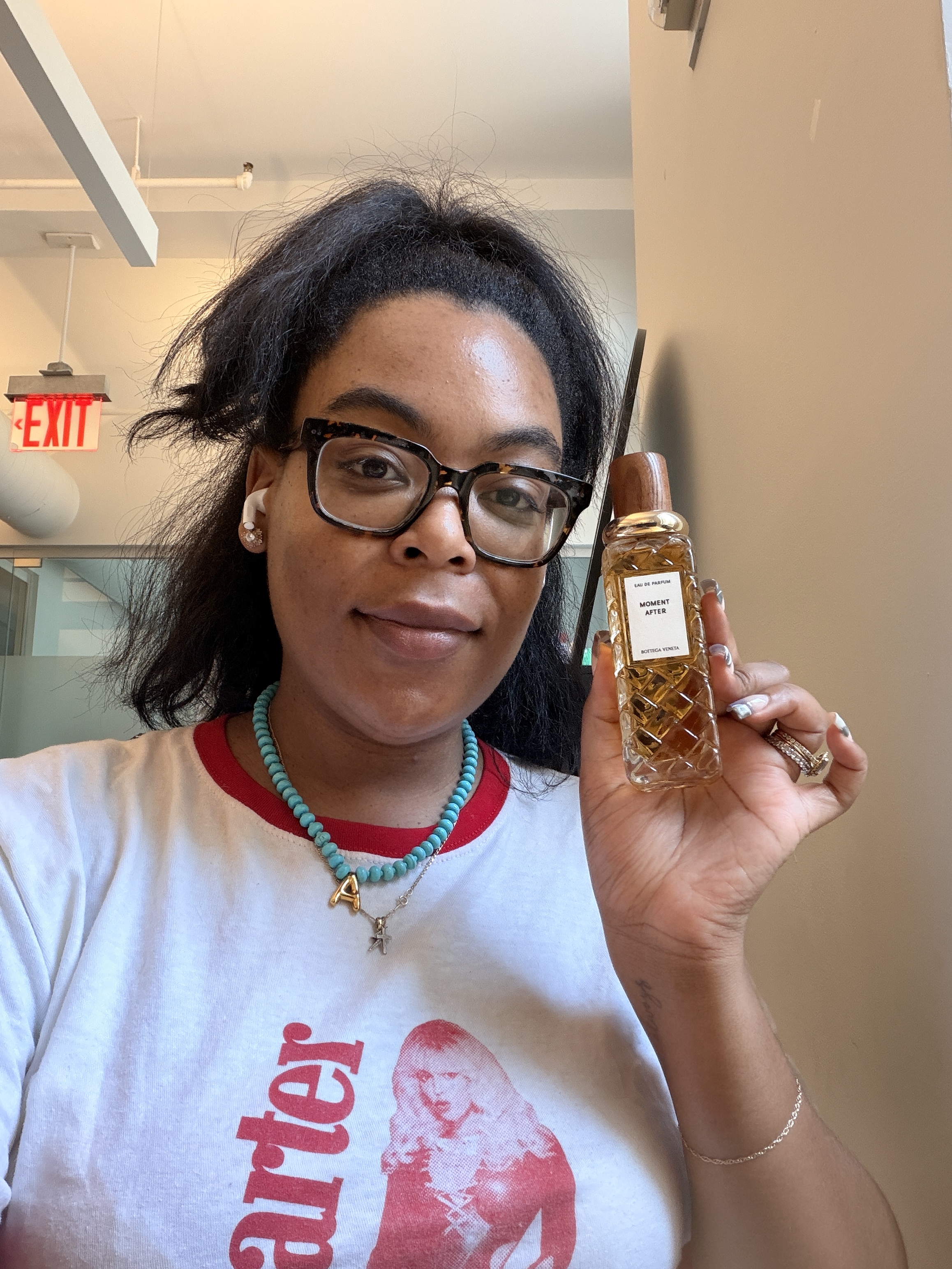 Ariel Baker holding a bottle of Morning After perfume from Bottega Veneta