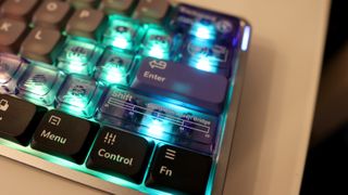 NuPhy Air60 HE gaming keyboard on a desk with RGB enabled.