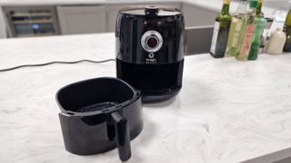 Magic Bullet air fryer with the drawer out on a white marble countertop