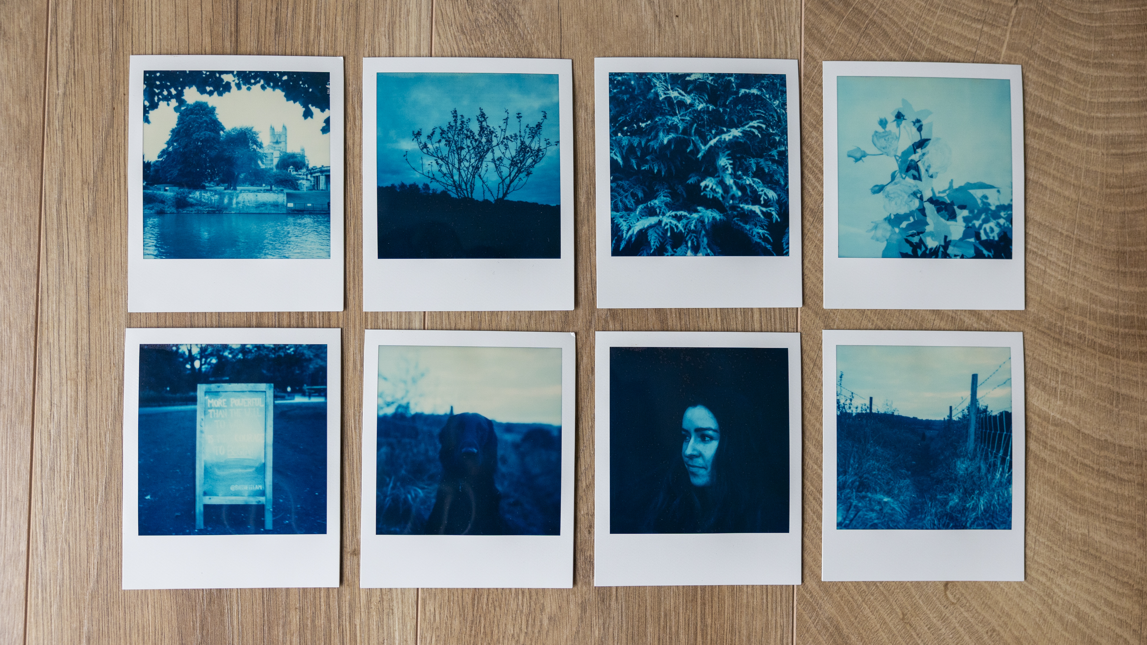 8 sheets of Polaroid Reclaimed Blue Film on a wooden floor