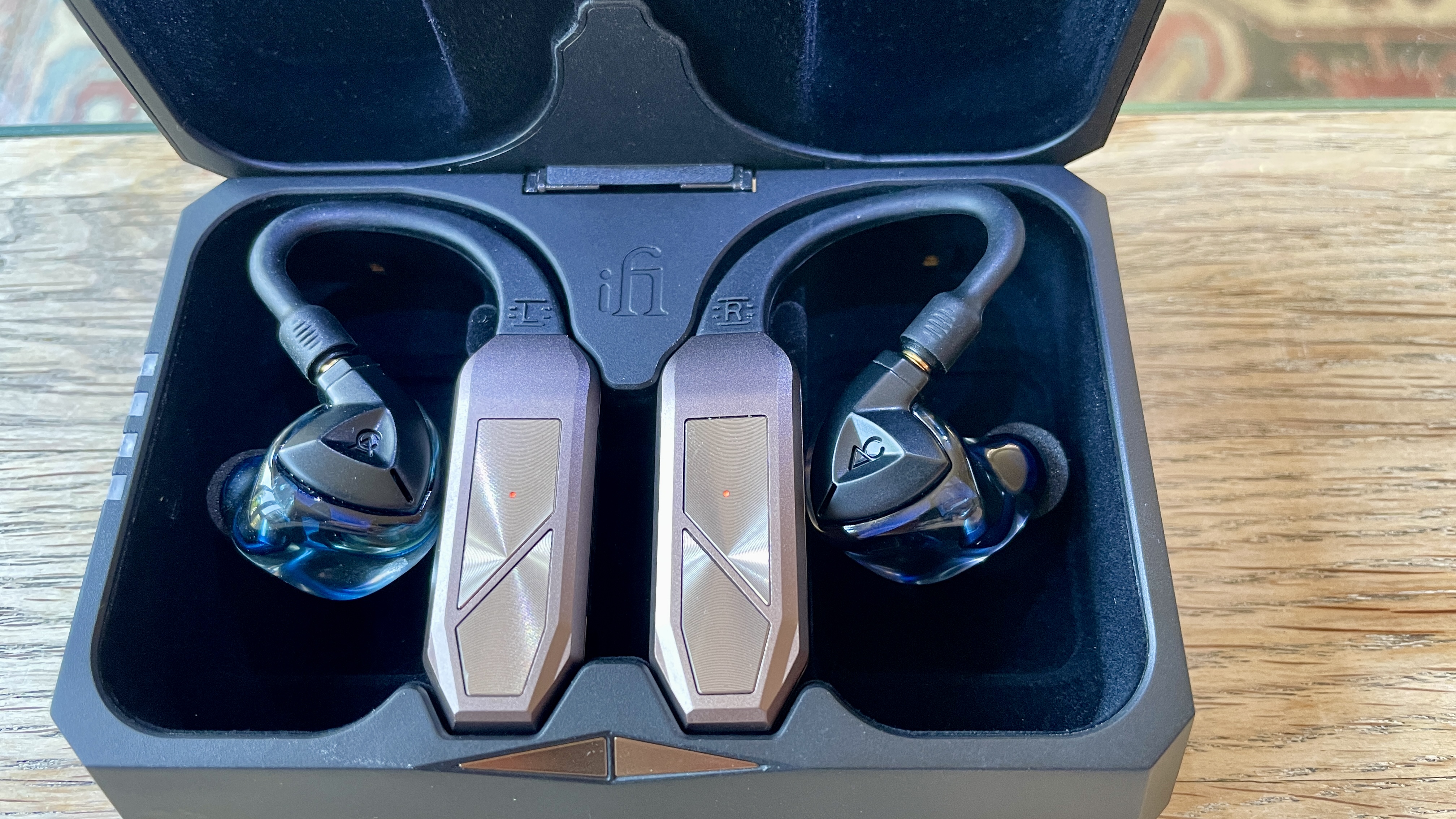 iFi Go Pod in a hand, with high-end wired earbuds and in the case, which accepts even larger earbuds