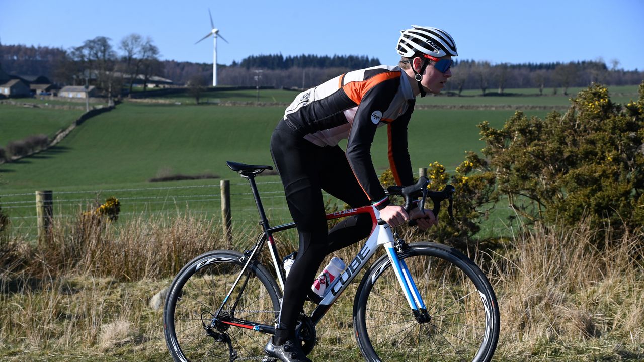 Image shows a person cycling outdoors