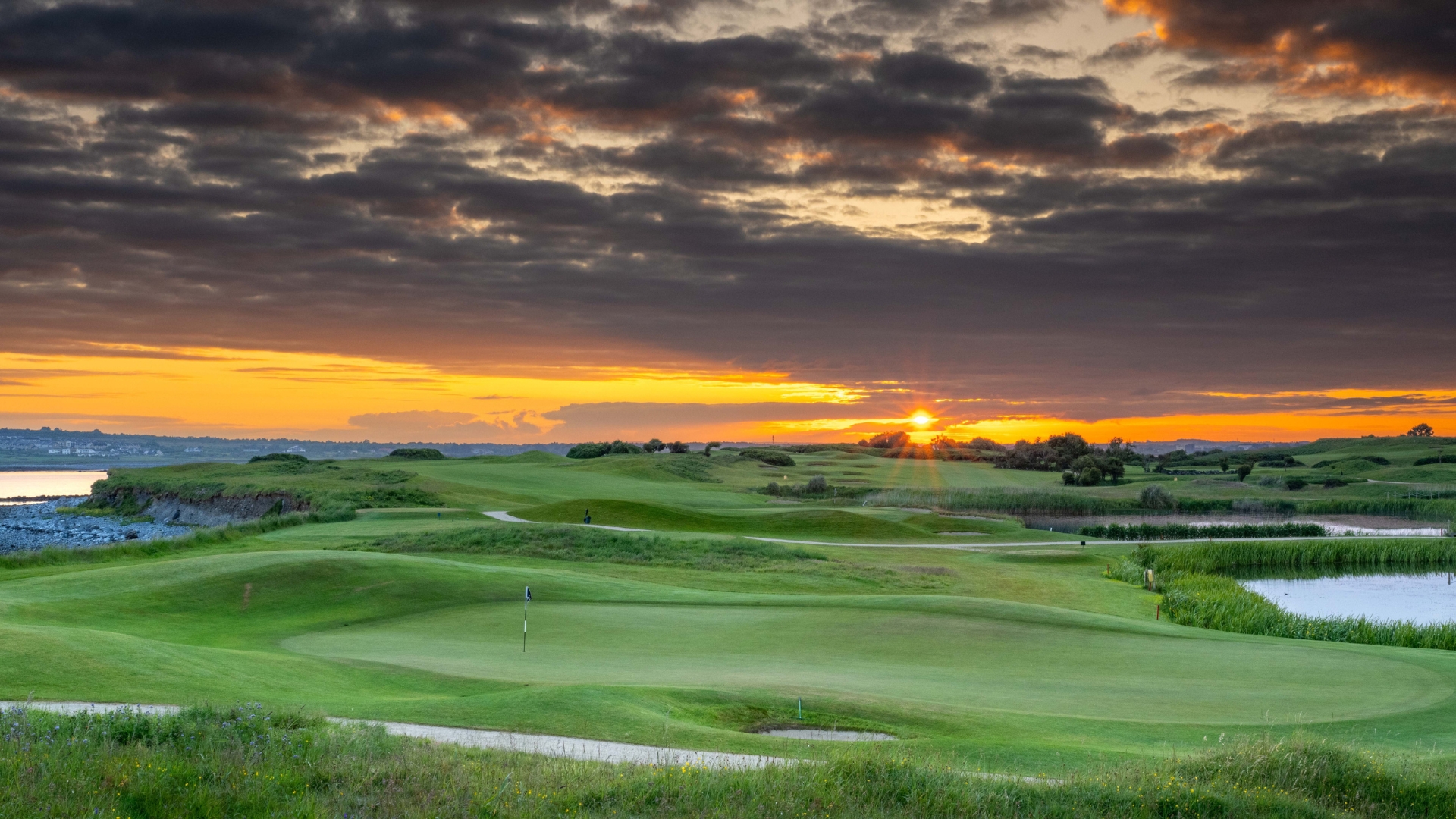 Looking back down a golf hole at The Hawthorn by Galway Bay at sunset