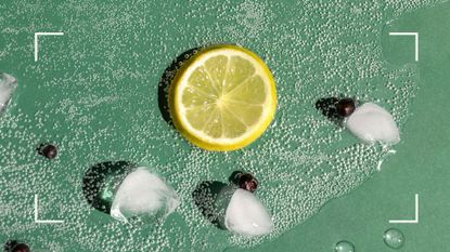 Close up shot of spilled gin and tonic over table with ice and lemon scattered, representing how to prevent a hangover