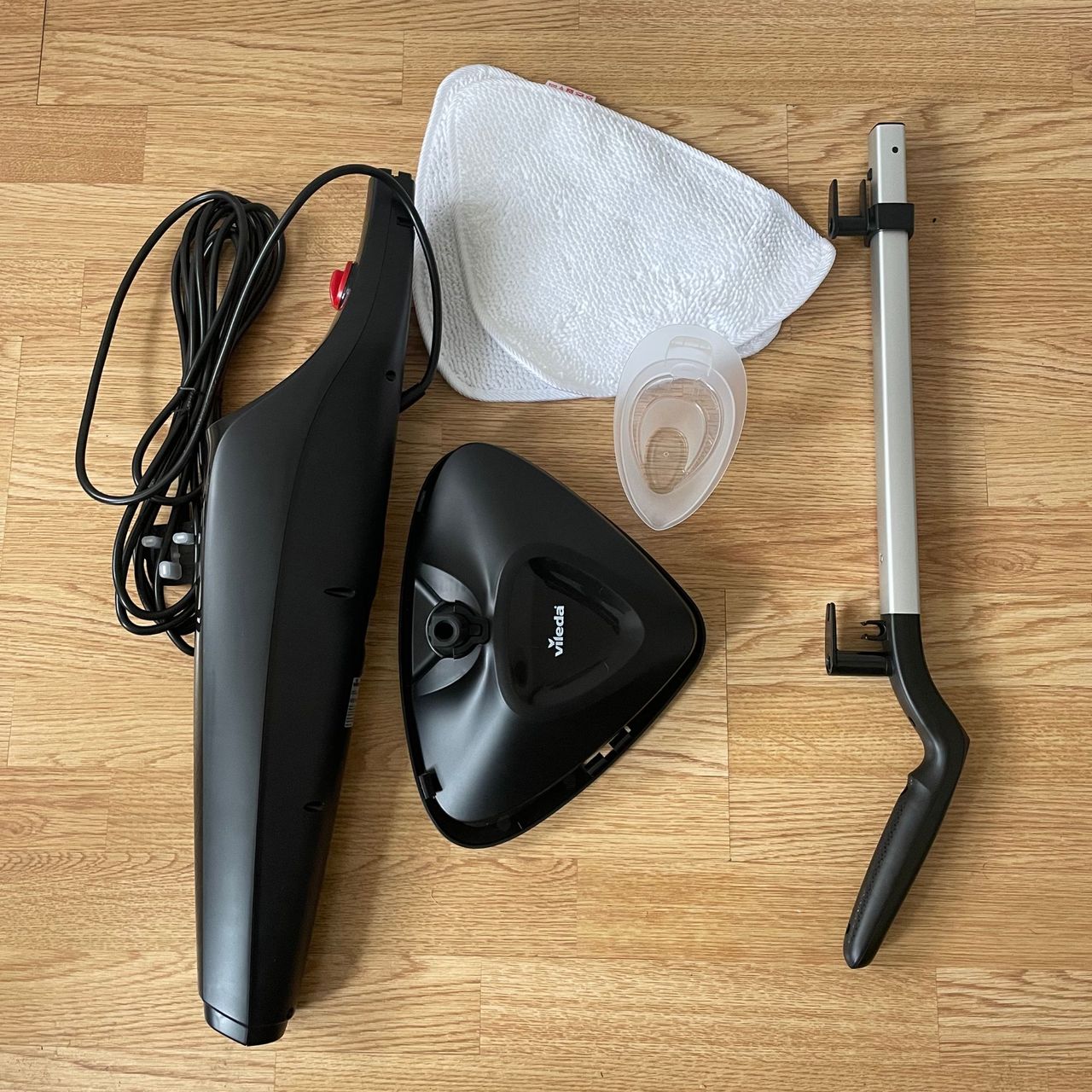 Vileda Steam Mop Plus components laid out on laminate flooring