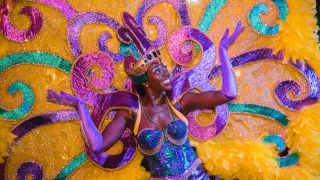 A performer shows off her costume at Universal Mardi Gras 2024.