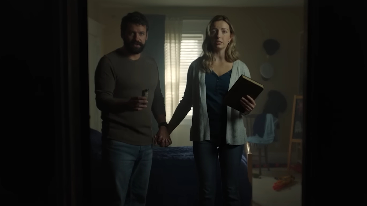 A couple standing with a bible and sage in True Haunting