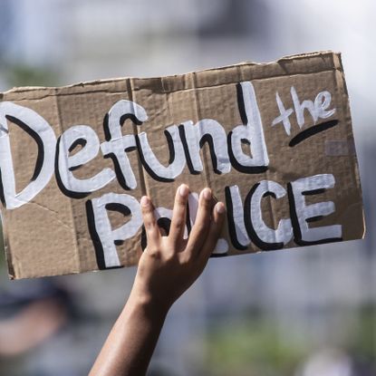 manhattan, ny june 19 a protester holds up a homemade sign that says, "defund the police" with the manhattan bridge behind them as they perform a peaceful protest walk across the brooklyn bridge this was part of the unite ny 2020, bringing all of new york together rally and march for black lives matter as protests that happened around the country to celebrate juneteenth day which marks the end of slavery in the united states protesters continue taking to the streets across america and around the world after the killing of george floyd at the hands of a white police officer derek chauvin that was kneeling on his neck during for eight minutes, was caught on video and went viral during his arrest as floyd pleaded, "i can't breathe" the protest are attempting to give a voice to the need for human rights for african american's and to stop police brutality against people of color they are also protesting deep seated racism in america many people were wearing masks and observing social distancing due to the coronavirus pandemic photographed in the manhattan borough of new york on june 19, 2020, usa photo by ira l blackcorbis via getty images