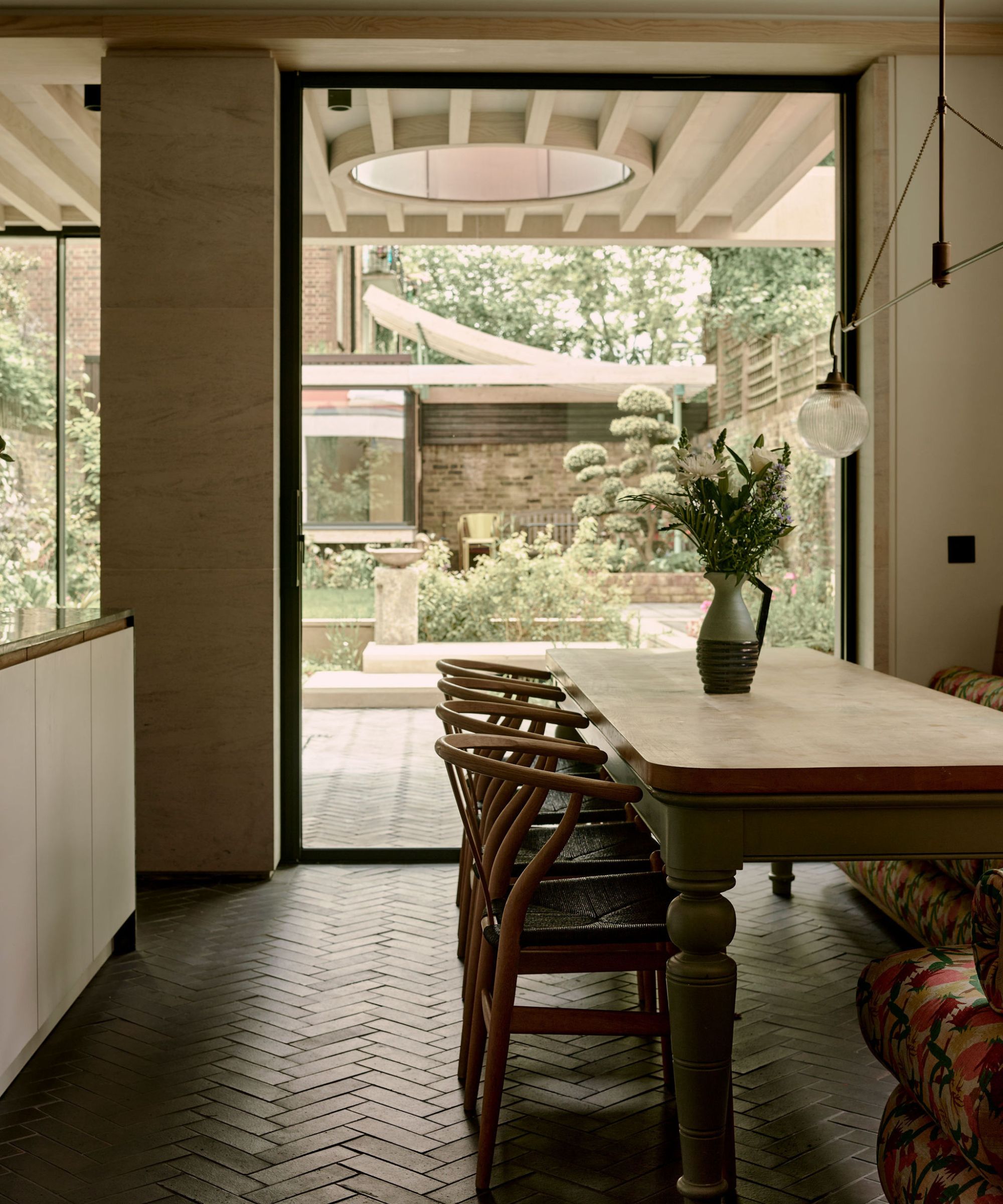 A modern rustic kitchen with a vintage light over the dining table