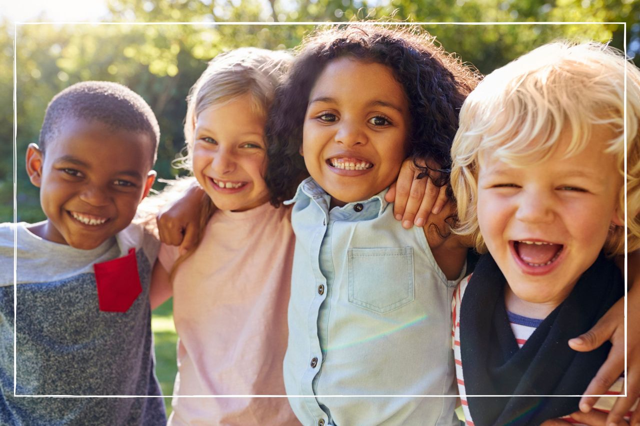 group of smiling kids, with arms around each other outside on a sunny day