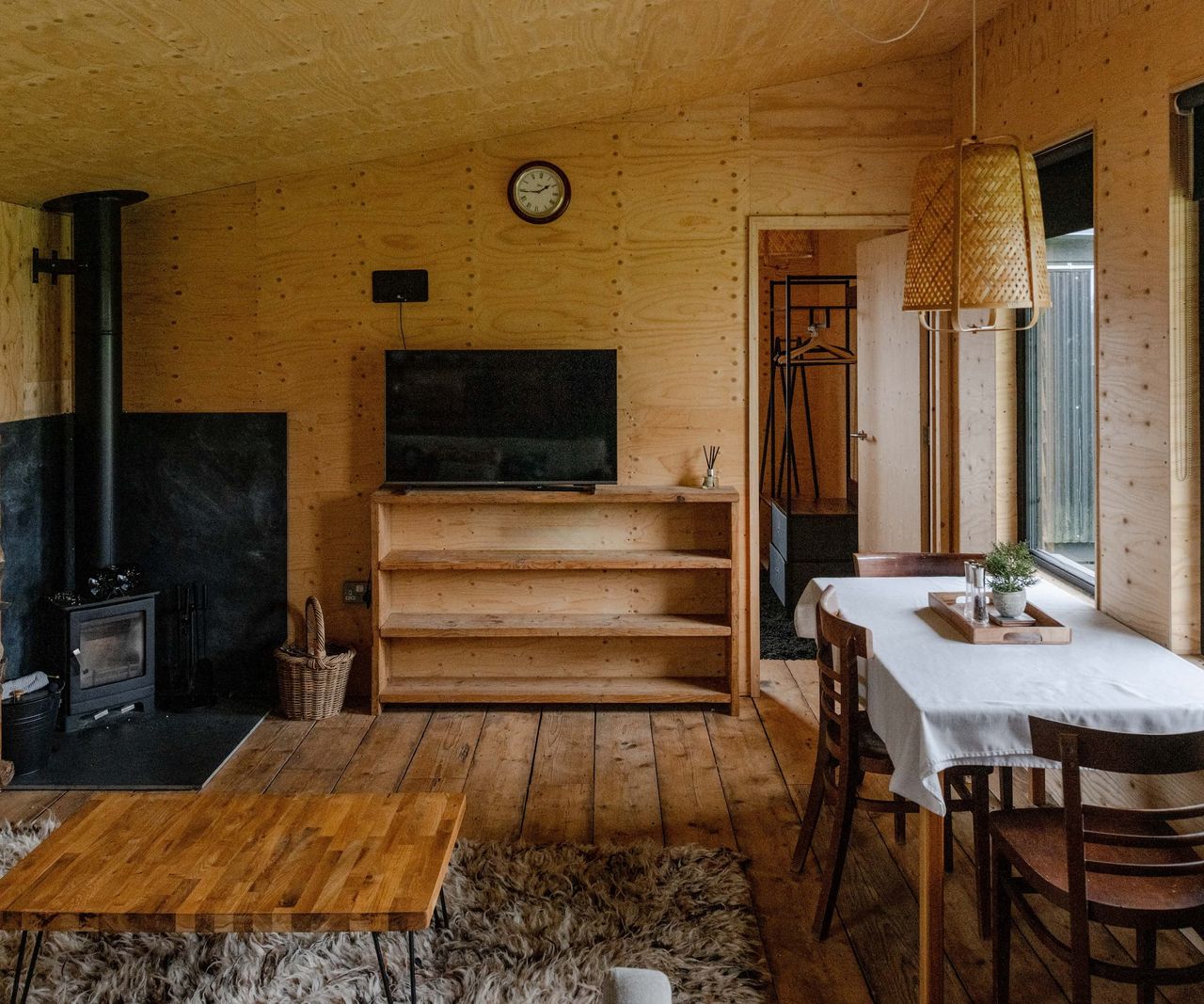 Inside an annexe and a woodburner with wooden floorboards and furniture
