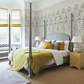 bedroom with grey designed wallpaper bed with designed cushion lamp and window