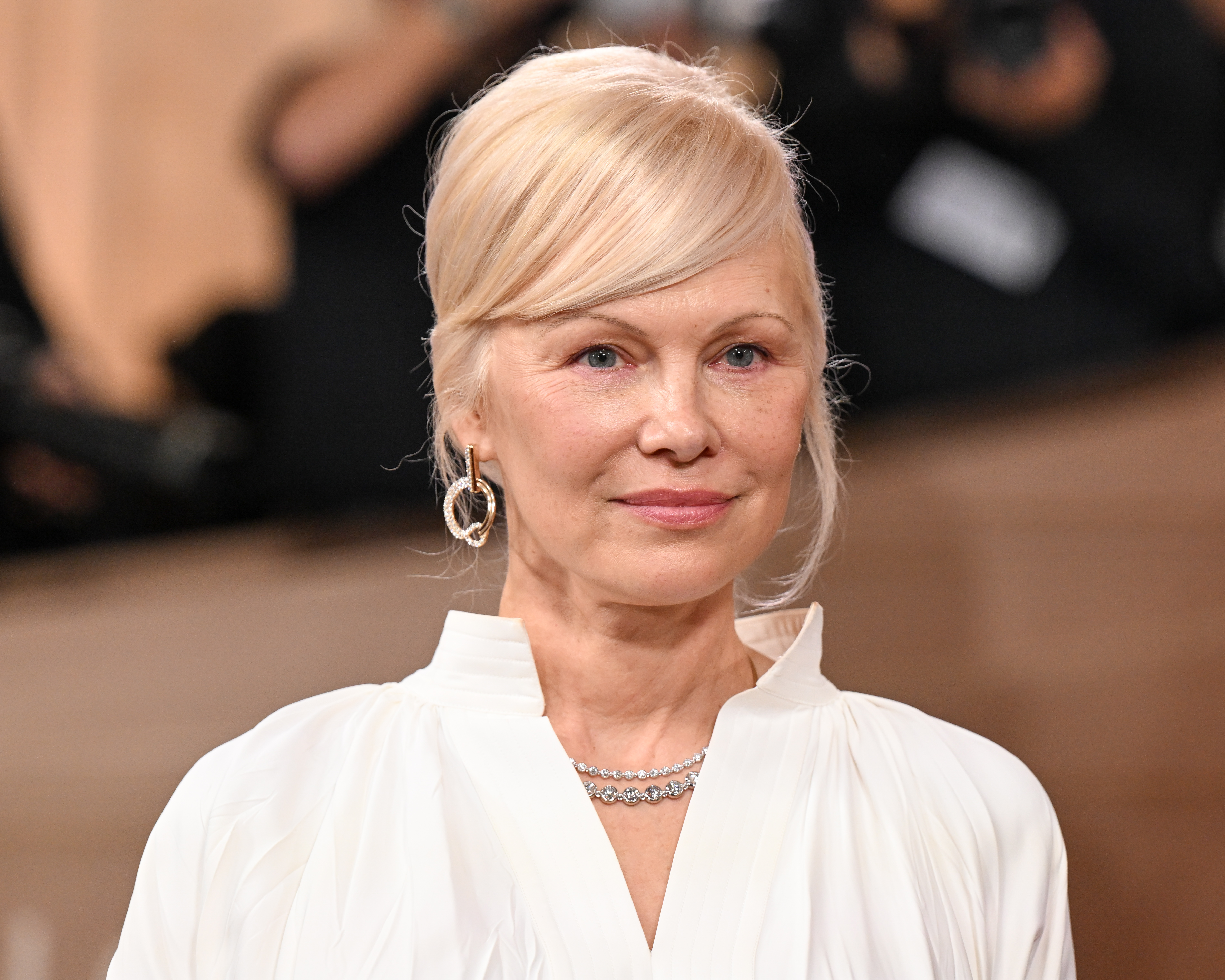 a white woman with blonde hair poses on the red carpet