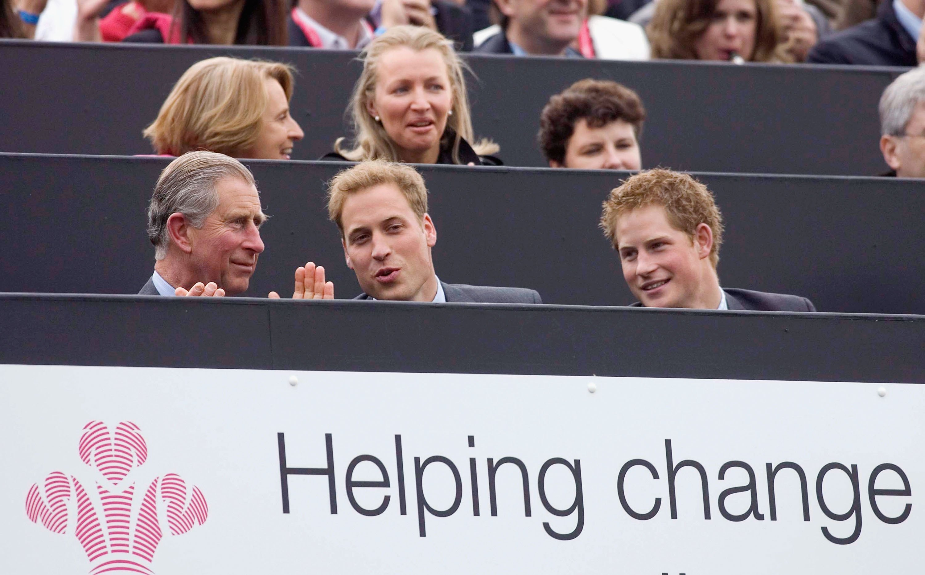 King Charles clapping next to Prince William and Prince Harry at a 2006 concert
