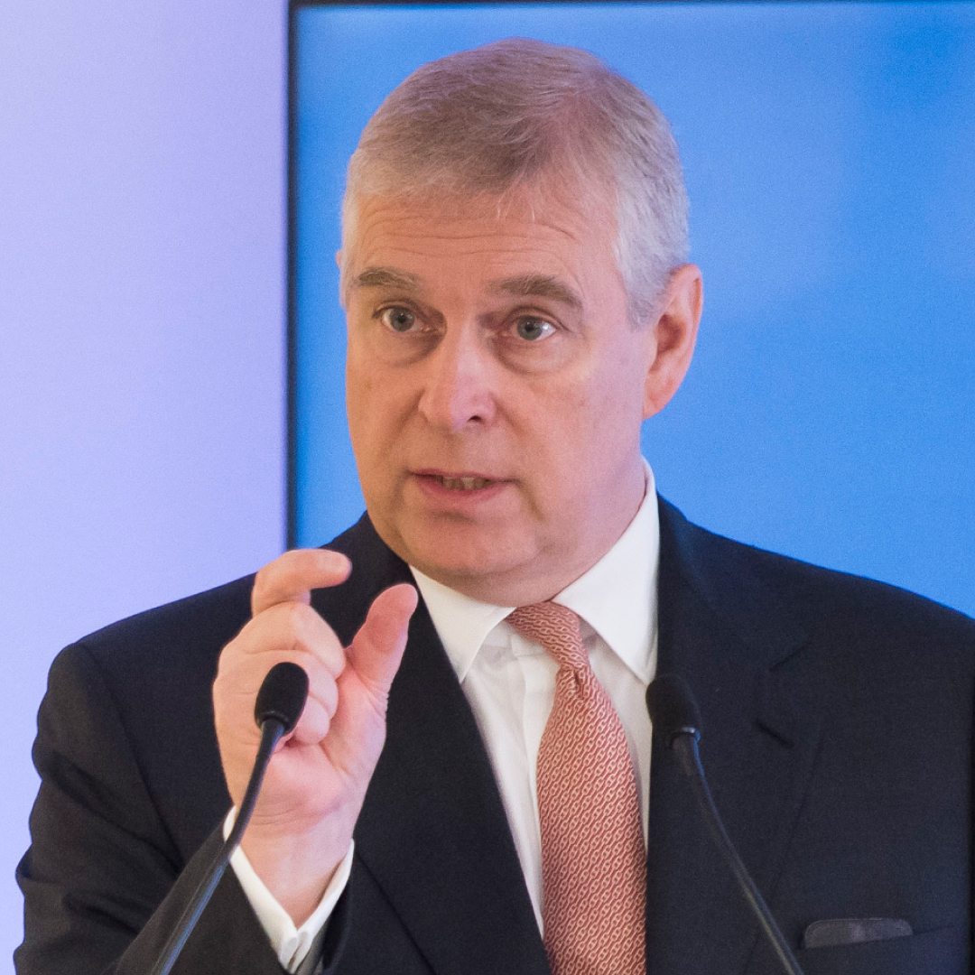 Ex-Prince Andrew gives a talk in 2017 while wearing a black suit, white shirt, and red tie