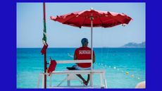 male lifeguard looking towards sea in lifeguard's uniform in Italy