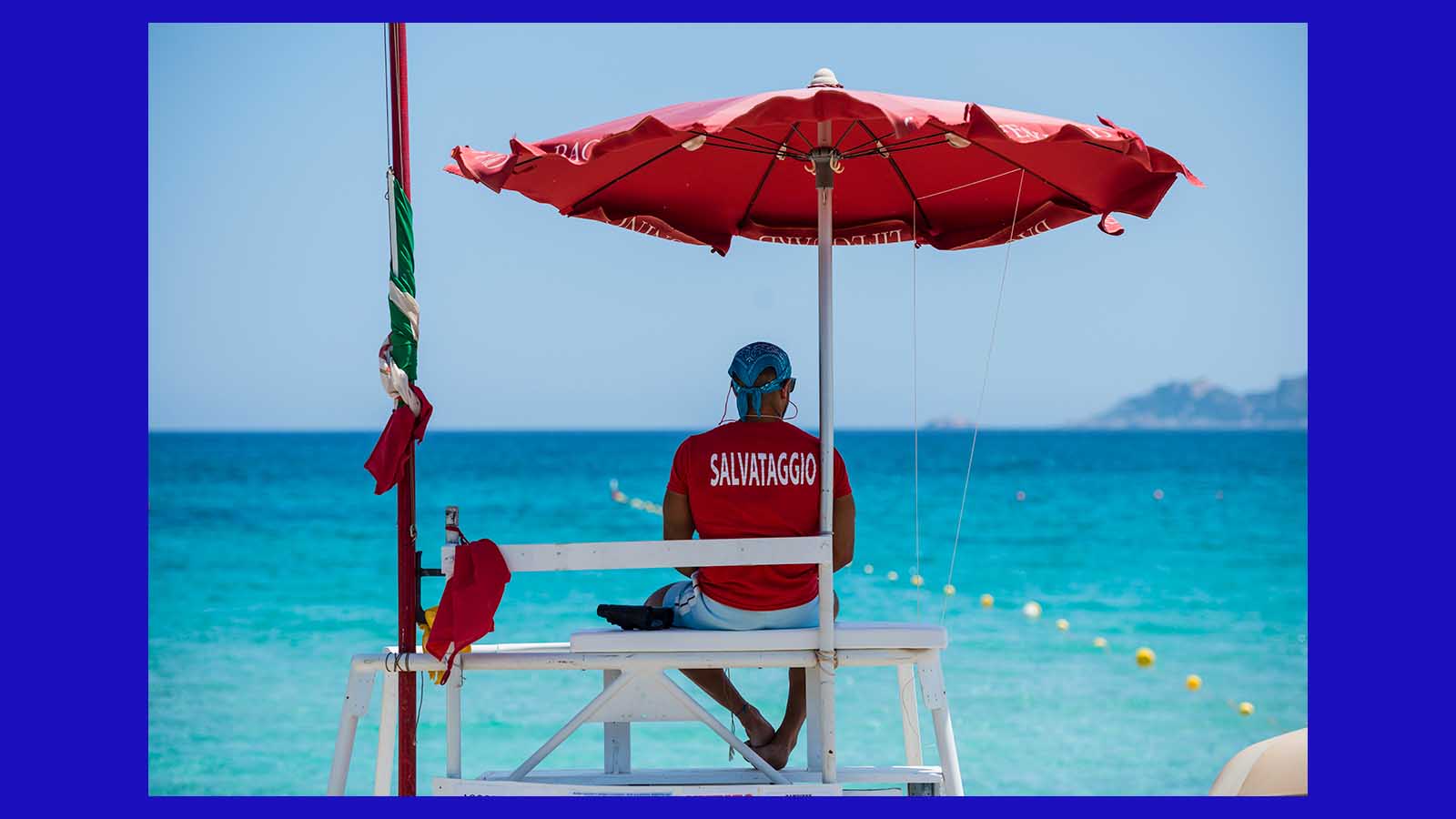 male lifeguard looking towards sea in lifeguard's uniform in Italy