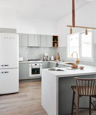 A grey kitchen by norsu interiors with Copper lighting fixtures