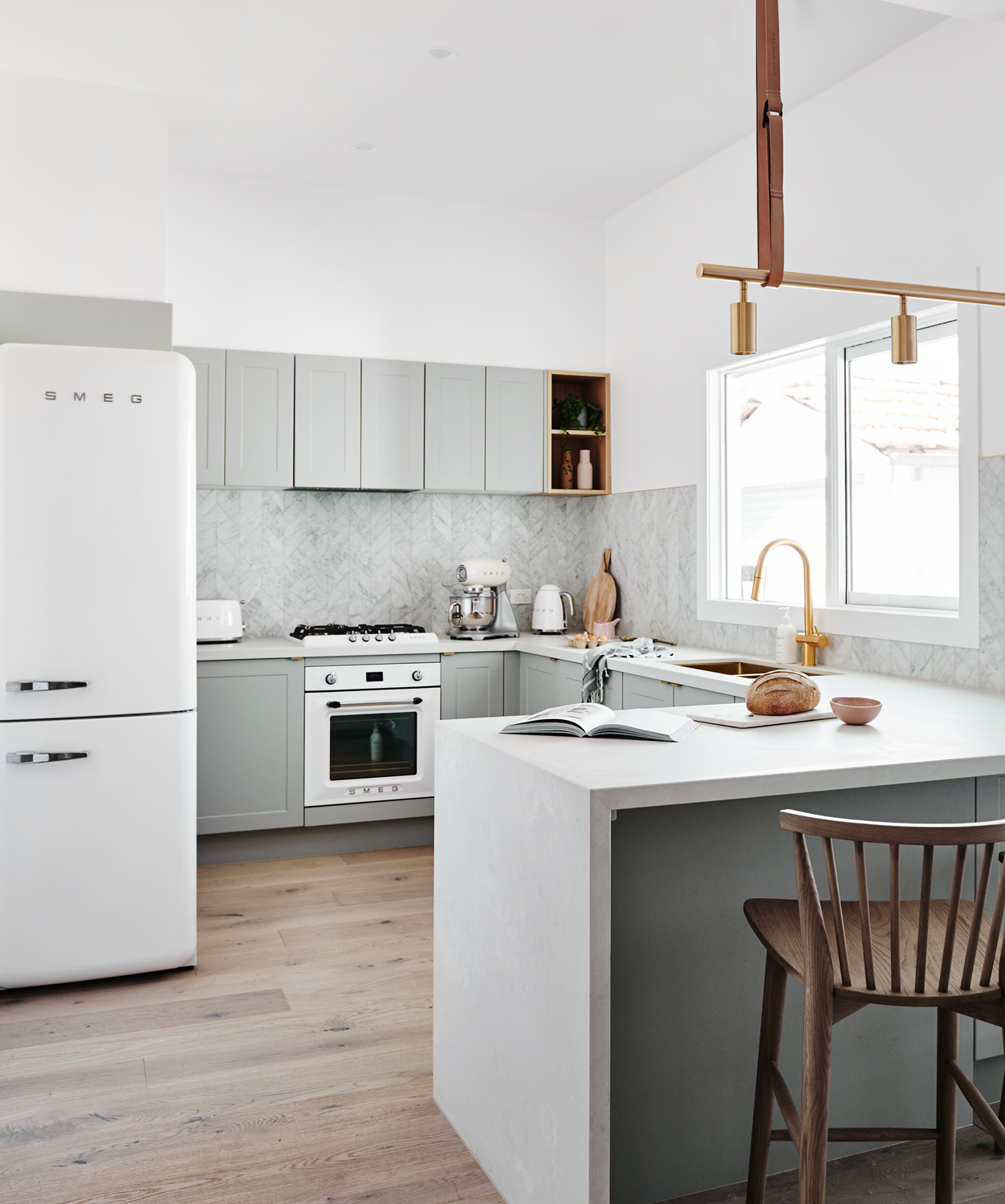 A grey kitchen by norsu interiors with Copper lighting fixtures