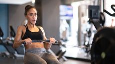 Woman doing a rowing machine workout as an alternative to running