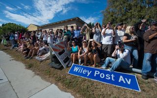 Spectators watch space shuttle Endeavour as it passes by on its way to the California Science Center in Los Angeles, Friday, Oct. 12, 2012.