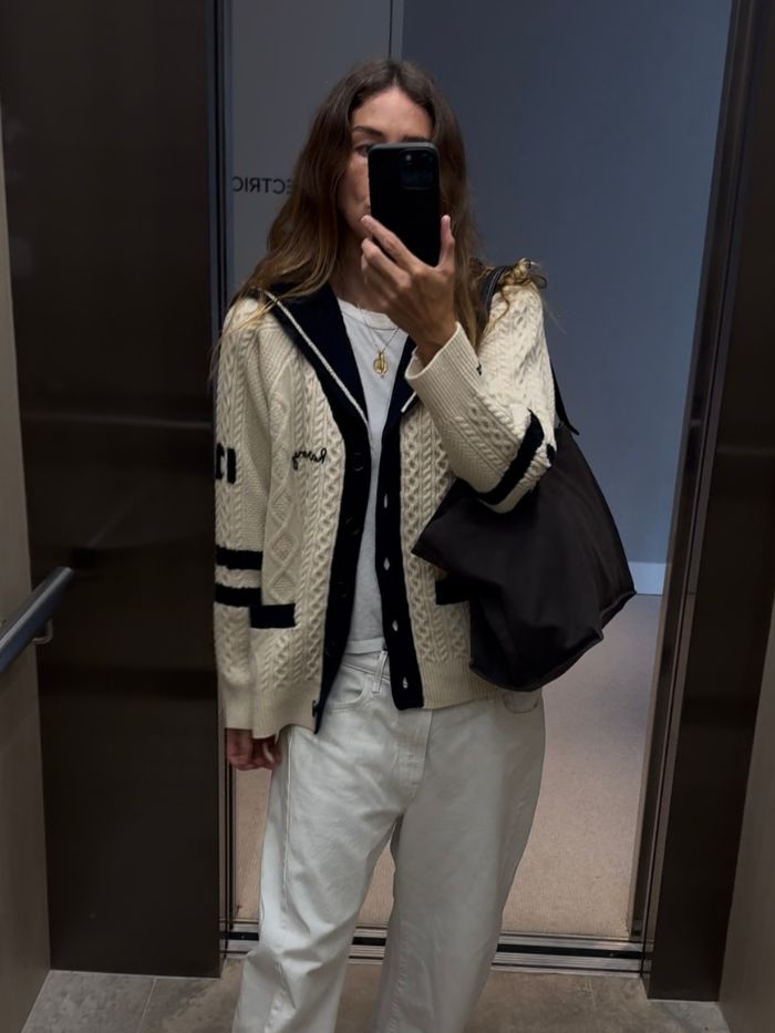 Angie wears a cream knit jumper