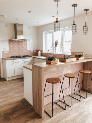 coral kitchen with coral tiles, wooden floors, mini kitchen island with breakfast bar