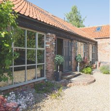 Gravel driveway patio in front garden with low-growing plants