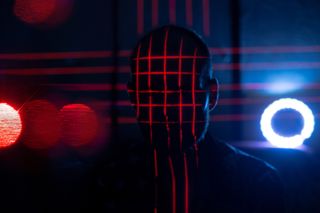 The outline of a mysterious figure surrounded by red and blue lights