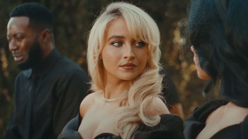 Sabrina Carpenter looking to her right at a woman with black hair. She looks serious. 