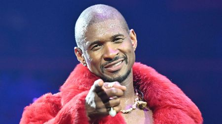 usher in a red coat on a blue background