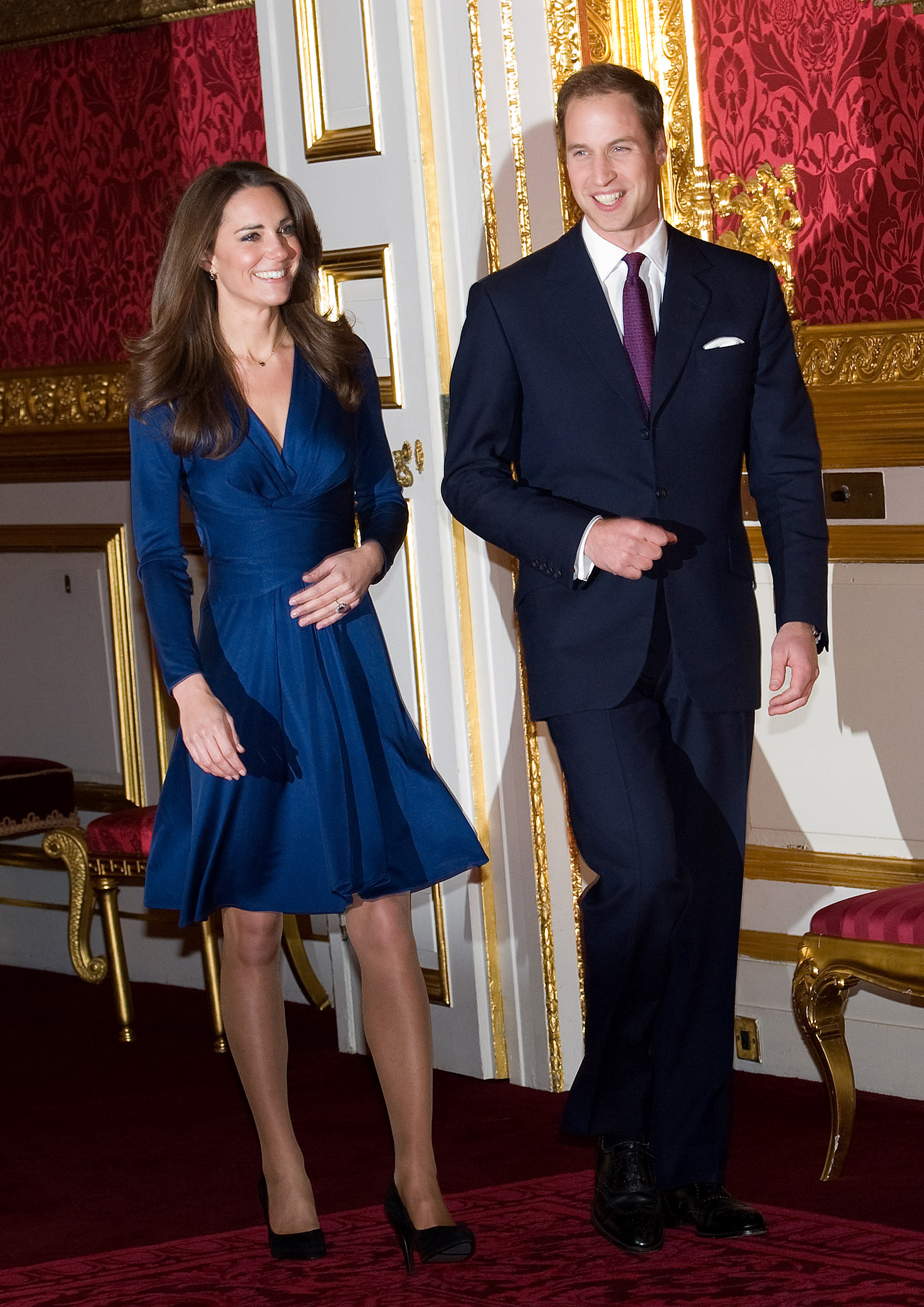 Kate Middleton wearing a blue dress walking next to Prince William at their engagement announcement press conference