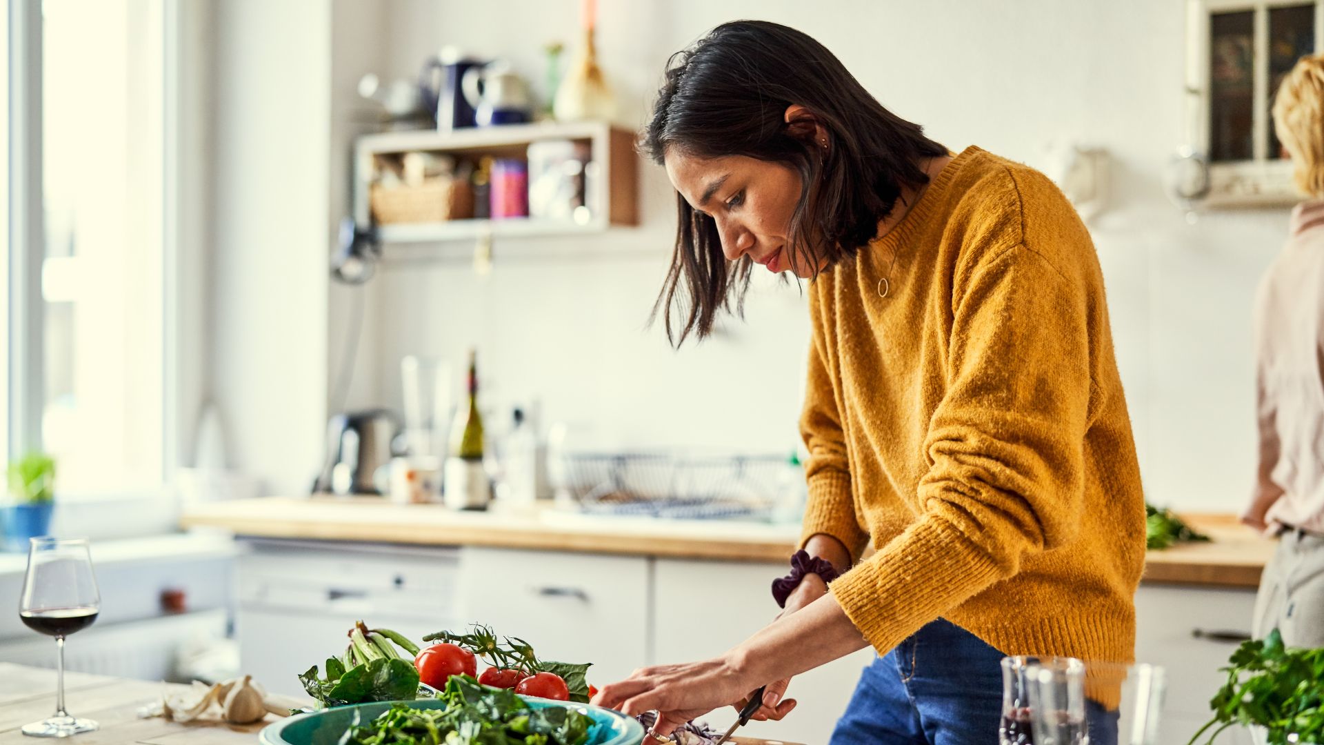 Woman chopping salad on chopping board