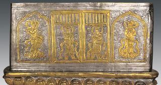 The silver casket found inside the stupa is decorated with images of gods guarding it with swords.