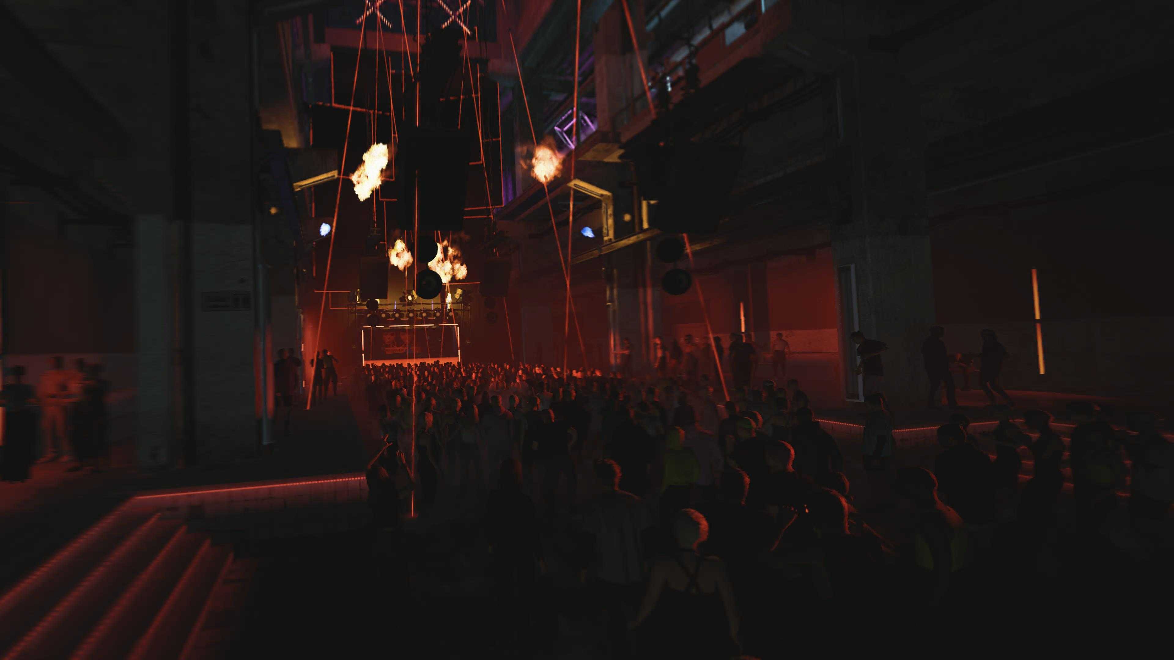 A view of a rave with fire and lasers accenting the DJ's set