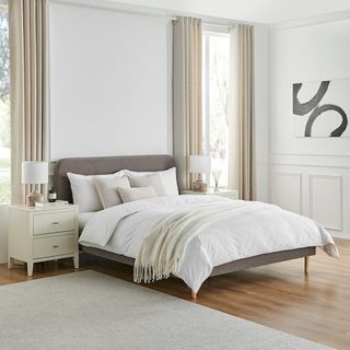 Grey bed frame in a white bedroom