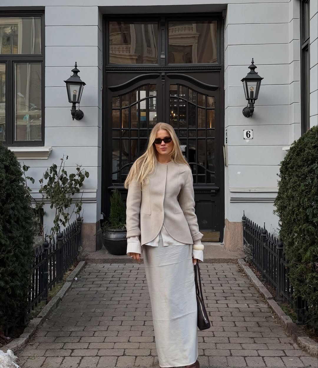 Andrea in a beige collarless blazer and matching skirt