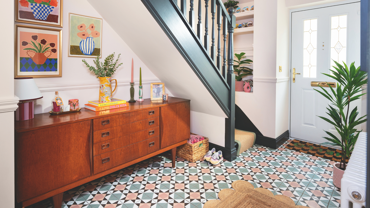 A wooden cabinet and drawers in a hallway under the stairs.