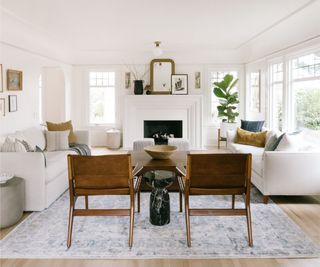 White sofas, wooden chairs, white fireplace, plant