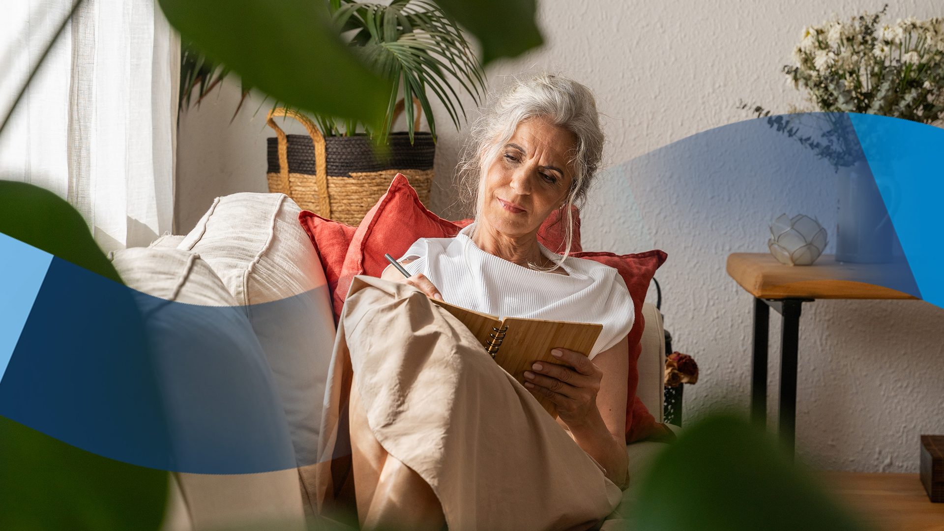 A woman sitting in a chair and writing in a notebook.