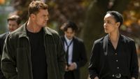 From left to right: Alan Ritchson lookint to his right at Maria Sten who is looking at him. 