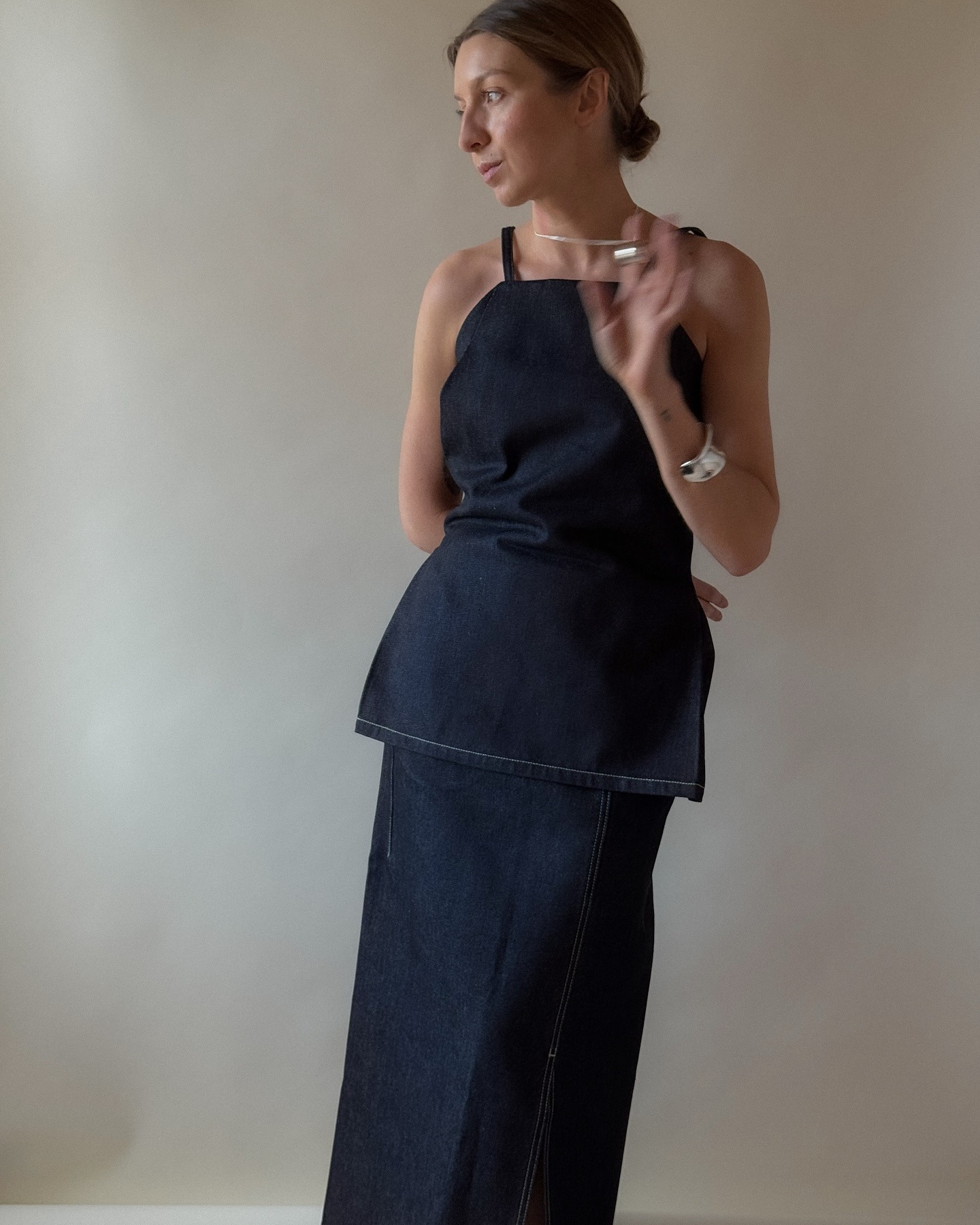 Influencer @brittanybathgate wears a COS denim halterneck top with a denim long-line pencil skirt.